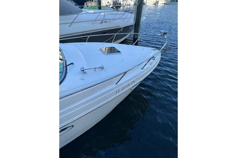 Slide: The Image of 2014 Rinker 260 Express Cruiser docked on calm water. - 2