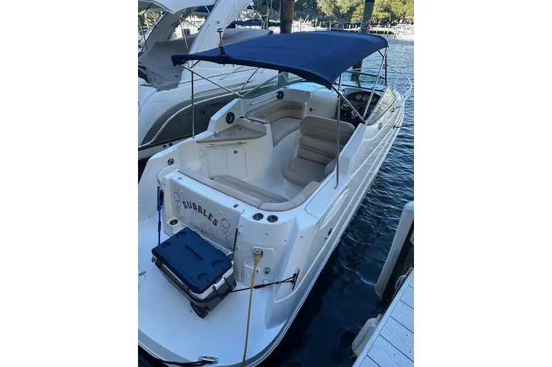 Slide: The Image of 2014 Rinker 260 Express Cruiser docked with blue canopy and spacious seating. - 6