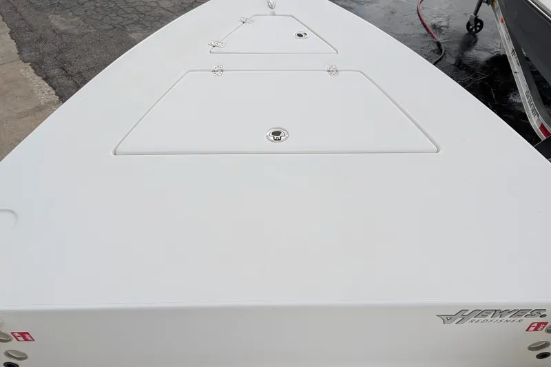 Slide: The Image of 2027 Hewes Redfisher 18 boat deck, featuring storage compartments and sleek design. - 16