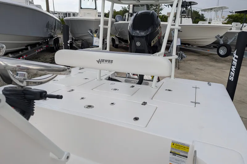 Slide: The Image of 2027 Hewes Redfisher 18 boat with Yamaha engine, displayed in a marina setting. - 8