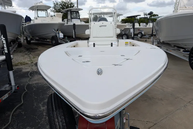 Slide: The Image of 2027 Hewes Redfisher 18 boat on display at a dealership, showcasing sleek design. - 28