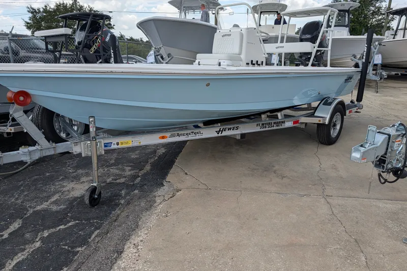 Slide: The Image of 2027 Hewes Redfisher 18 boat on trailer, displayed outdoors at a dealership. - 2