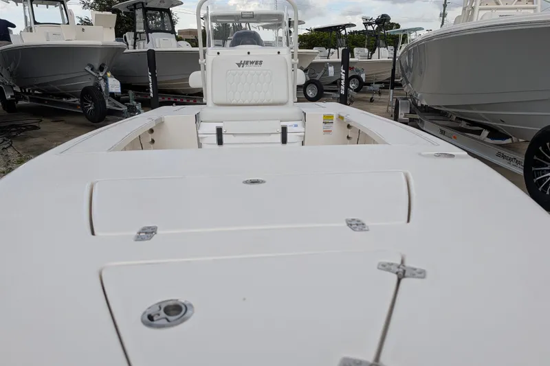 Slide: The Image of 2027 Hewes Redfisher 18 boat, white deck, parked among other boats at a marina. - 26
