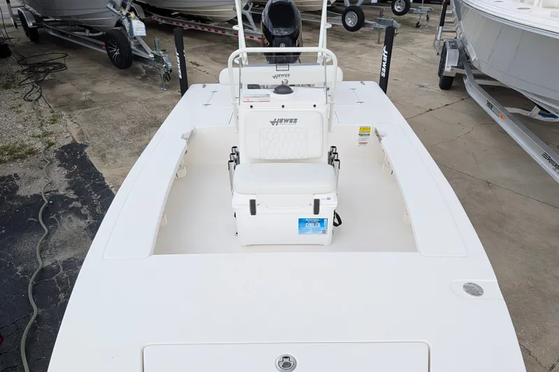 Slide: The Image of 2027 Hewes Redfisher 18 boat with seating and cooler, displayed on a concrete surface. - 19