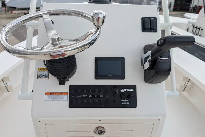 Slide: The Image of 2027 Hewes Redfisher 18 boat console with steering wheel and Yamaha controls. - 11