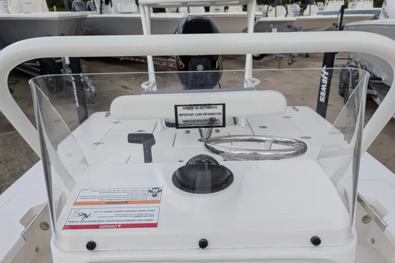 Slide: The Image of 2027 Hewes Redfisher 18 boat console with steering wheel and safety warnings. - 20