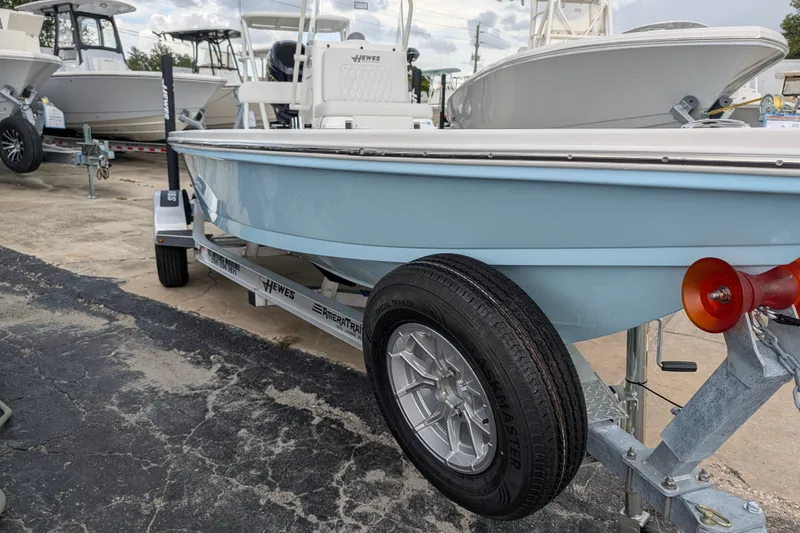 Slide: The Image of 2027 Hewes Redfisher 18 boat on trailer, displayed in a marina setting. - 3