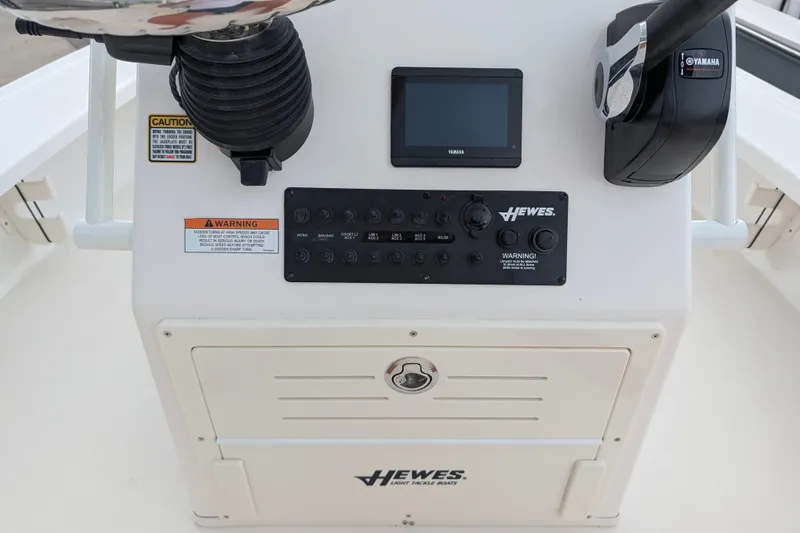 Slide: The Image of 2027 Hewes Redfisher 18 boat console with Yamaha controls and warning labels. - 12
