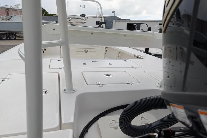 Slide: The Image of 2027 Hewes Redfisher 18 boat deck with storage compartments and motor detail. - 29