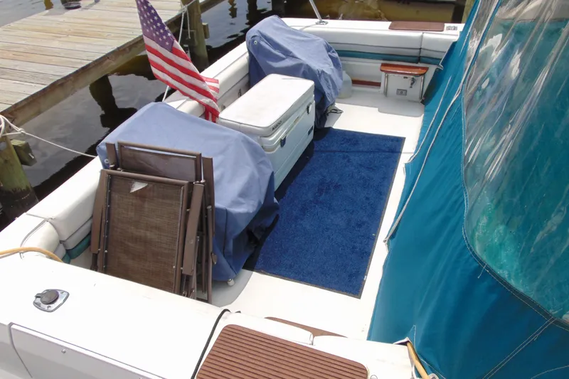 Slide: The Image of 1988 TROJAN INTERNATIONAL 10M boat deck with chairs, cooler, and American flag. - 17