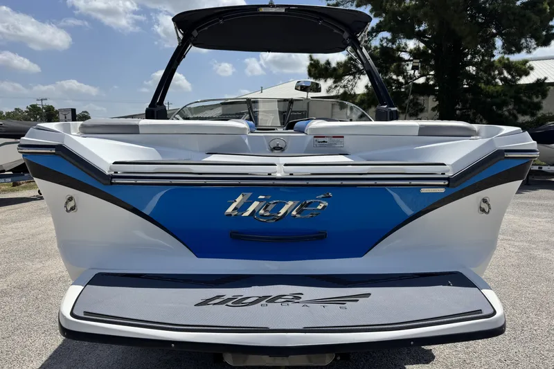 Slide: The Image of 2014 Tigé Z1 boat, rear view, blue and white design, parked outdoors. - 5