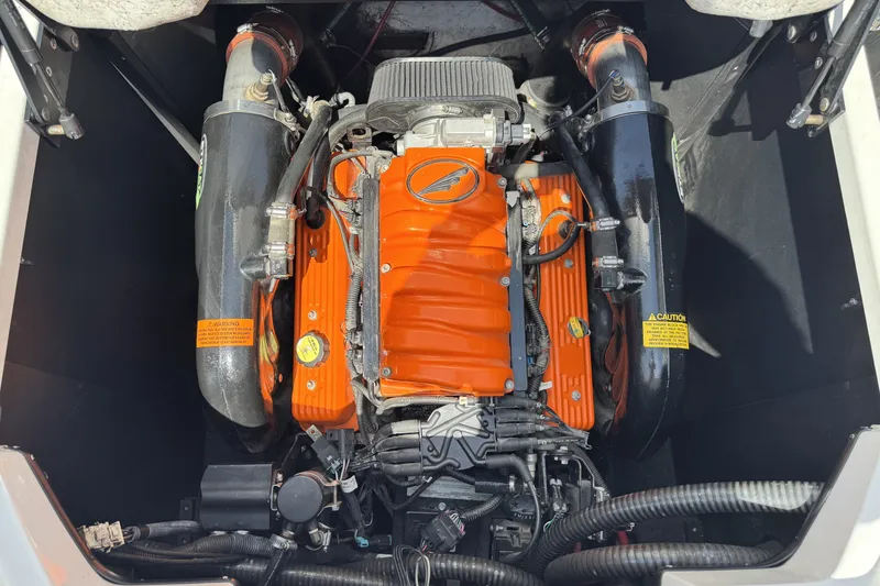 Slide: The Image of Engine of a 2014 Tigé Z1 boat with orange components and black hoses. - 18