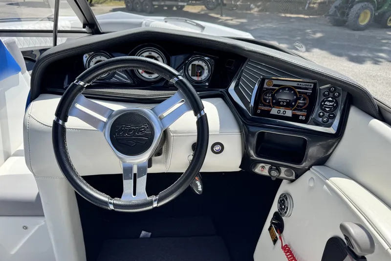 Slide: The Image of Steering wheel and dashboard of a 2014 Tigé Z1 boat, featuring modern gauges and controls. - 12