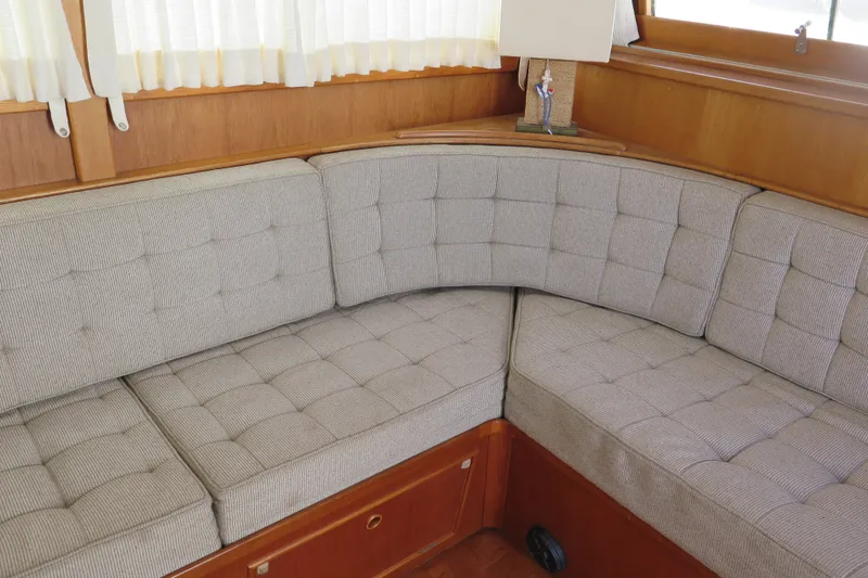 Slide: The Image of Cozy seating area on a 1988 Grand Banks 36 Classic yacht with tufted cushions. - 21