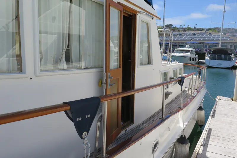 Slide: The Image of 1988 Grand Banks 36 Classic yacht docked at marina, showcasing elegant wooden railings. - 8