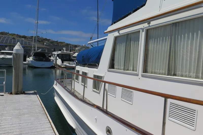 Slide: The Image of 1988 Grand Banks 36 Classic yacht docked at marina under clear blue sky. - 4