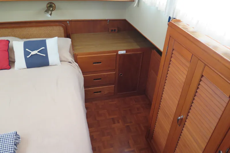 Slide: The Image of Interior of 1988 Grand Banks 36 Classic yacht with wooden cabinetry and cozy bedding. - 27