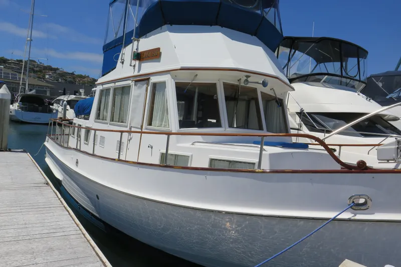 Slide: The Image of 1988 Grand Banks 36 Classic yacht docked at marina under clear blue sky. - 1