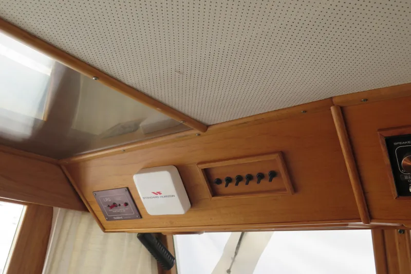 Slide: The Image of Interior controls of a 1988 Grand Banks 36 Classic yacht, featuring wooden paneling and switches. - 18