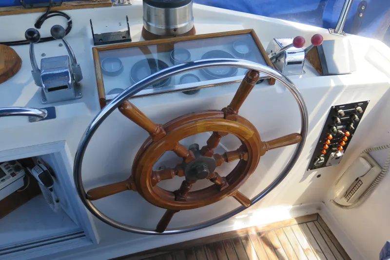 Slide: The Image of Wooden helm of 1988 Grand Banks 36 Classic yacht with control panel and throttle levers. - 9