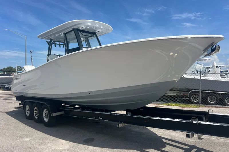 The Image of 2027 Sportsman Open 282 Center Console boat on trailer under clear blue sky. - 1