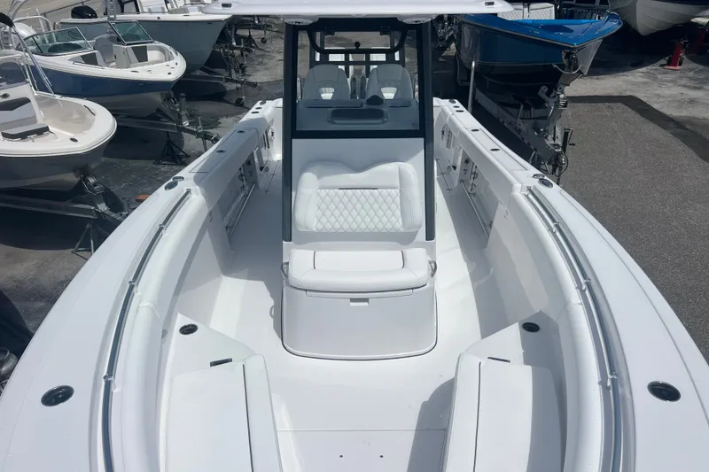 Slide: The Image of 2027 Sportsman Open 282 Center Console boat, sleek design, spacious seating, docked among other boats. - 14