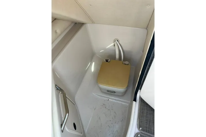 Slide: The Image of 2003 Sea Ray 240 Sundeck interior with portable toilet and storage area. - 9
