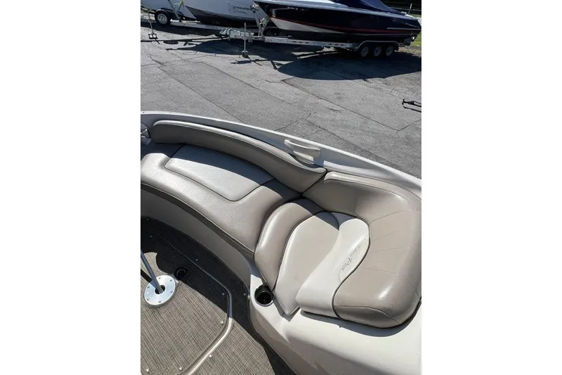 Slide: The Image of 2003 Sea Ray 240 Sundeck boat interior with beige seating and carpeted floor. - 5