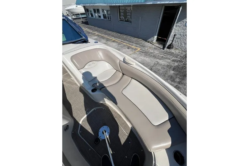Slide: The Image of 2003 Sea Ray 240 Sundeck boat interior with beige seating and cup holders. - 4