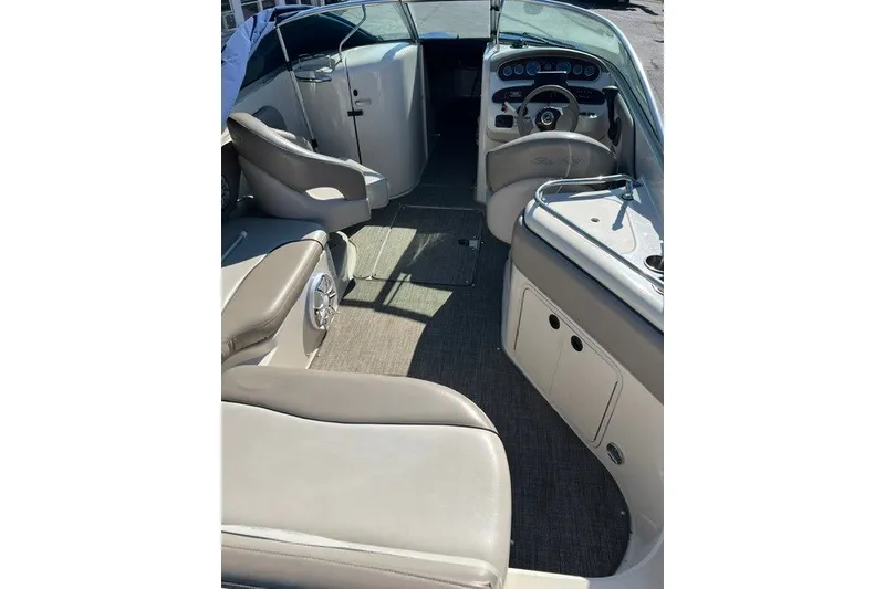 Slide: The Image of 2003 Sea Ray 240 Sundeck interior with seating and helm, showcasing spacious design. - 11