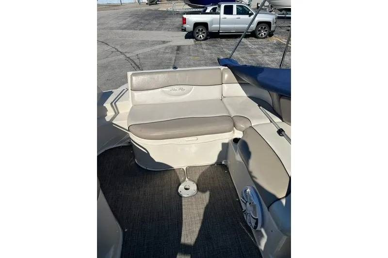 Slide: The Image of 2003 Sea Ray 240 Sundeck interior with beige seating and carpeted floor. - 10