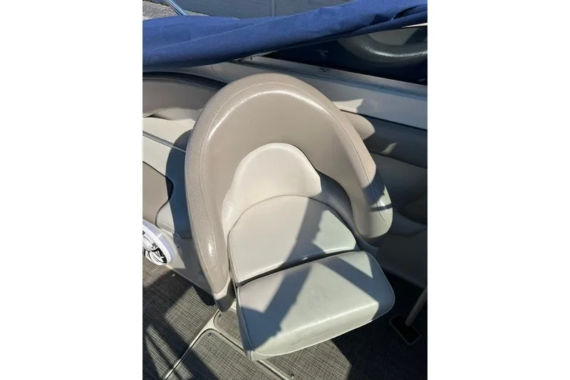 Slide: The Image of Captain's seat on a 2003 Sea Ray 240 Sundeck boat, featuring beige upholstery. - 8