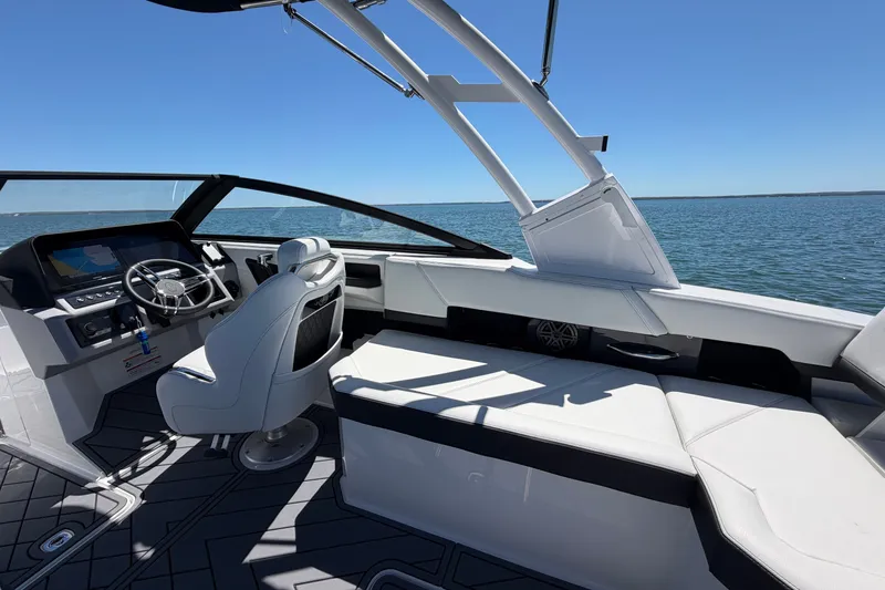 Slide: The Image of 2027 Cobalt R6 Outboard boat interior with steering wheel and seating, on open water. - 11