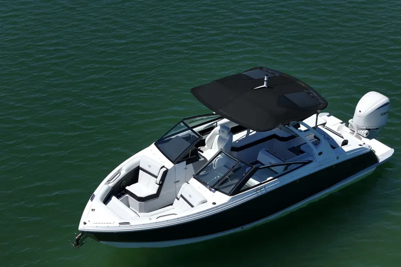 Slide: The Image of 2027 Cobalt R6 Outboard boat on calm green water, featuring sleek design and black canopy. - 5