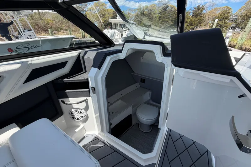 Slide: The Image of Interior of 2027 Cobalt R6 Outboard boat featuring a compact cabin with a toilet. - 18