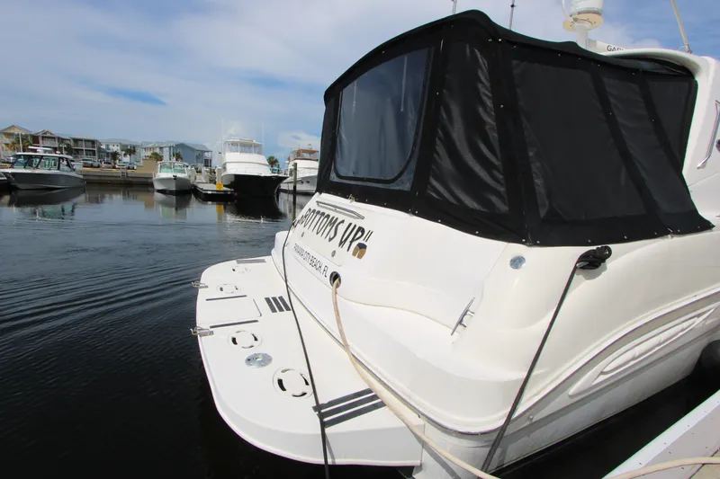Slide: The Image of 2001 Sea Ray Sundancer 460 yacht docked in a marina, featuring sleek design and black canopy. - 4