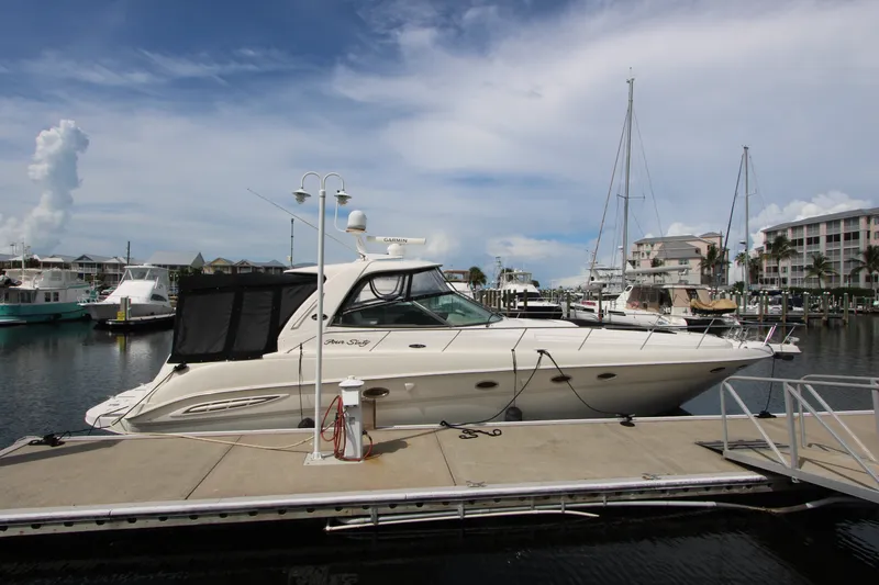 Slide: The Image of 2001 Sea Ray Sundancer 460 yacht docked at a marina under a clear sky. - 2