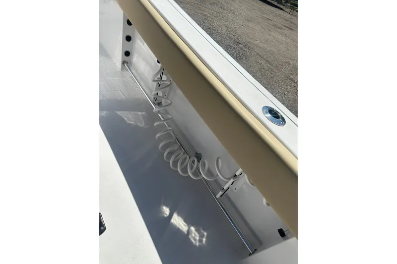 Slide: The Image of 2026 Sportsman Open 232 Center Console boat interior detail with coiled hose and rod holder. - 11