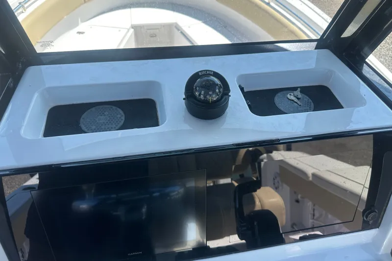 Slide: The Image of 2026 Sportsman Open 232 Center Console dashboard with compass and storage compartments. - 30