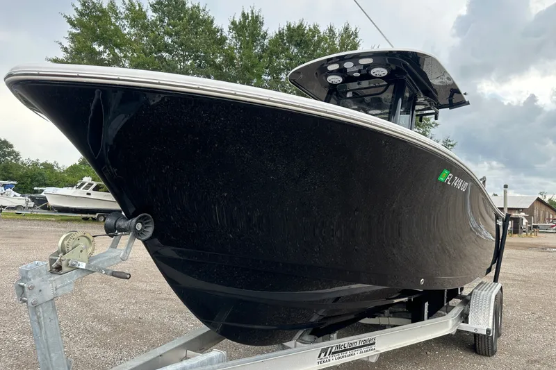 Slide: The Image of 2026 Sportsman Open 232 Center Console boat on trailer, parked outdoors. - 2