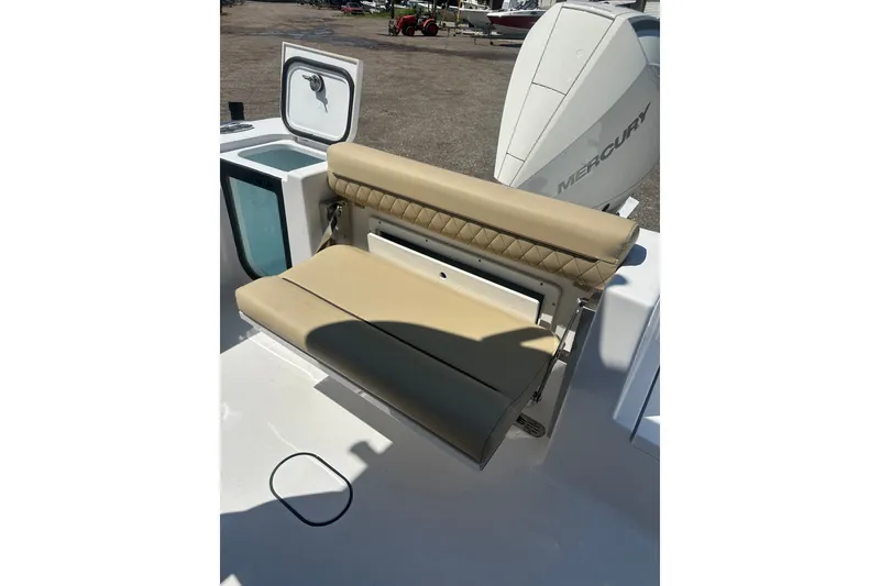 Slide: The Image of 2026 Sportsman Open 232 Center Console boat with tan foldable seat and Mercury engine. - 7