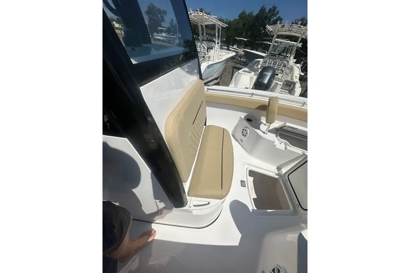 Slide: The Image of 2026 Sportsman Open 232 Center Console boat interior with tan seating and storage compartments. - 15