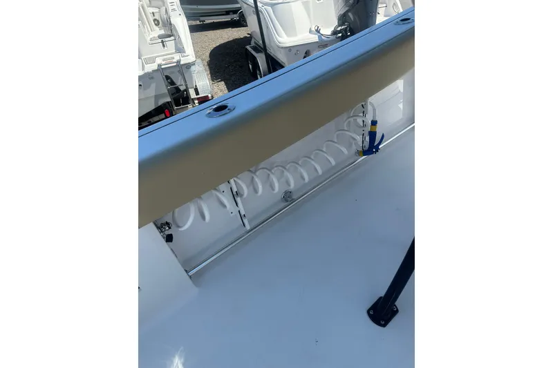 Slide: The Image of 2026 Sportsman Open 232 Center Console boat interior with coiled hose and seating. - 10