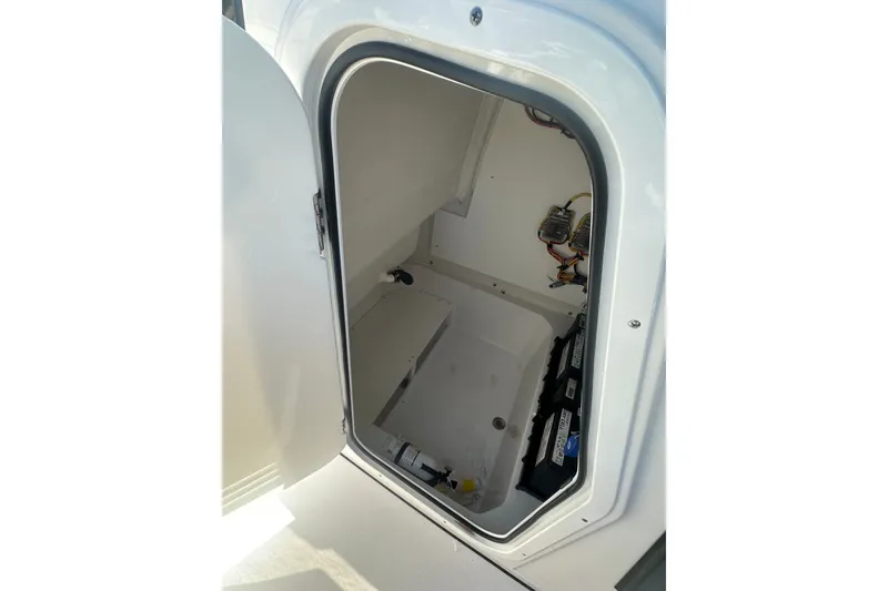 Slide: The Image of 2026 Sportsman Open 232 Center Console storage compartment with wiring and battery setup. - 17