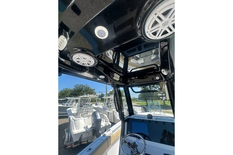 Slide: The Image of 2026 Sportsman Open 232 Center Console boat interior with speakers and steering wheel. - 13