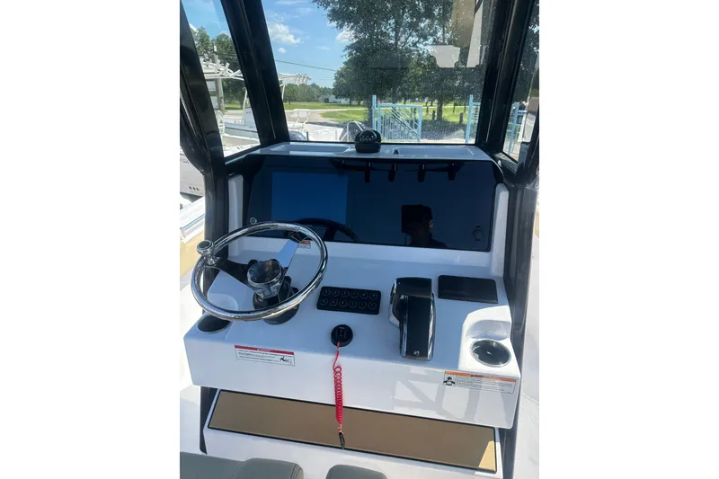 Slide: The Image of 2026 Sportsman Open 232 Center Console boat dashboard with steering wheel and controls. - 12