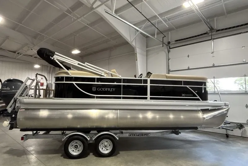 Slide: The Image of 2027 Godfrey XPERIENCE 2086 pontoon boat in a garage on a trailer. - 1