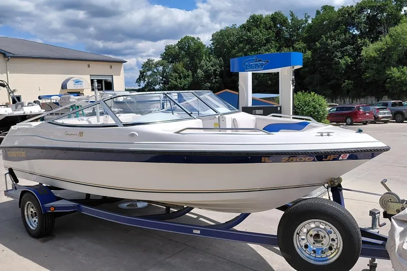 The Image of 1999 Ebbtide Campione 190 boat on trailer, parked outdoors near marina. - 0
