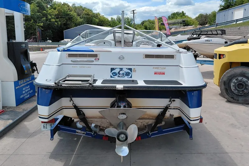 Slide: The Image of 1999 Ebbtide Campione 190 boat at a marina, rear view with propeller visible. - 4