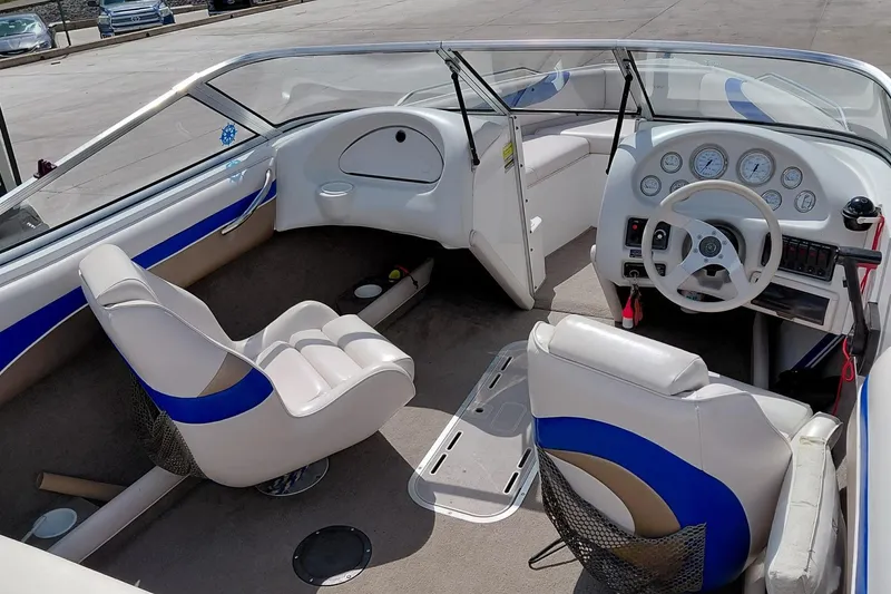 Slide: The Image of 1999 Ebbtide Campione 190 boat interior with white seating and dashboard controls. - 13